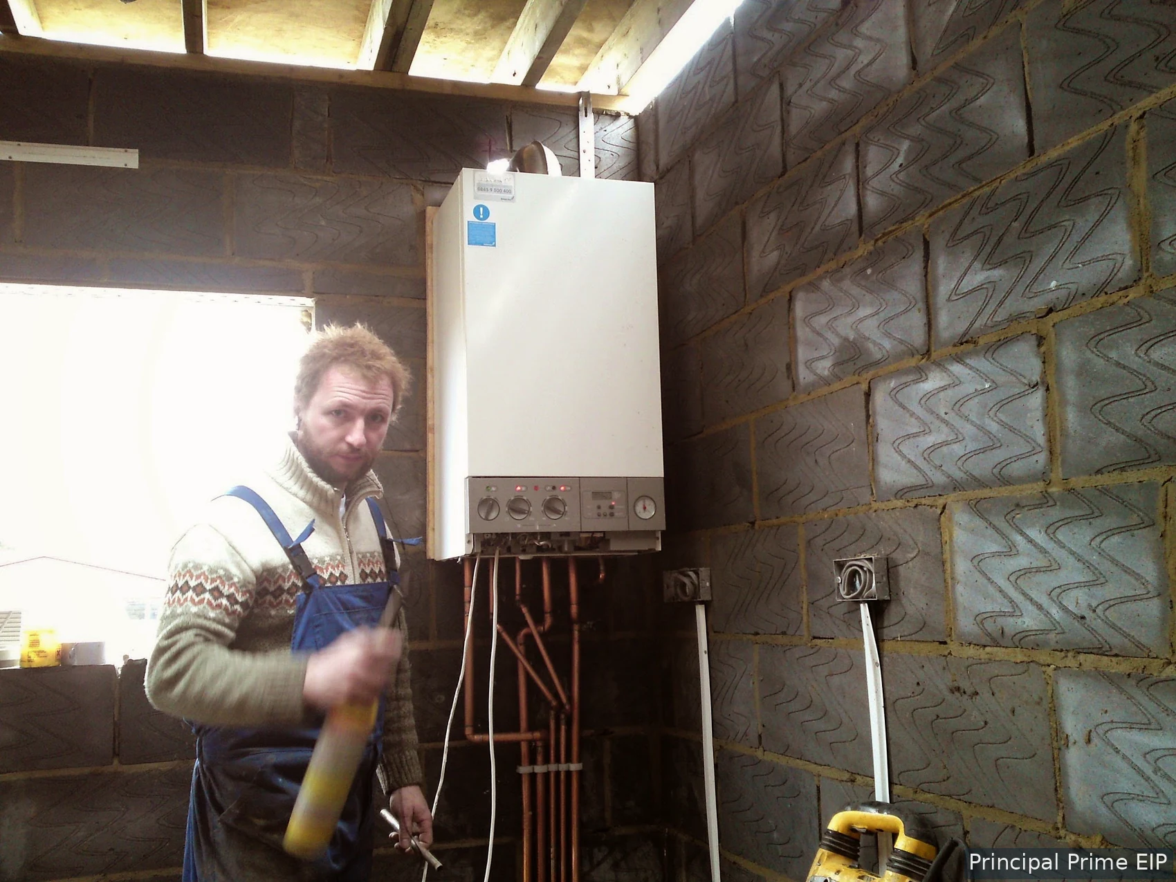 Plumber beside an installed boiler and pipework Plumber beside an installed boiler and pipework