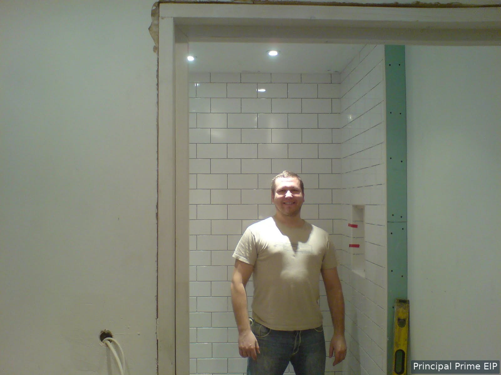 Tiler beside a newly tiled shower enclosure Tiler beside a newly tiled shower enclosure.